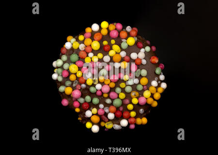 Macro image of a 'freckle', chocolate bud coated in sprinkles, isolated on a black background Stock Photo