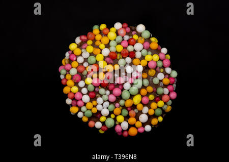 Macro image of a 'freckle', chocolate bud coated in sprinkles, isolated on a black background Stock Photo