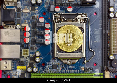 Top view of golden bit coin on computer mother board processor.Bitcoin mining farm, working computer equipment concept. Stock Photo