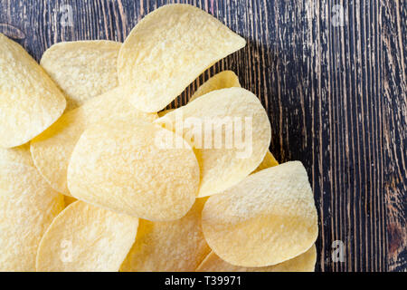 light-colored thin potato chips made from mashed potatoes, natural to the harmful product on the table Stock Photo