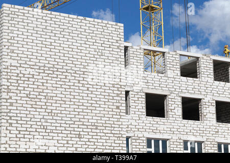 construction of a new multi-storey building of white gas silicate bricks, a multi-storey structure with residential apartments at the beginning of con Stock Photo