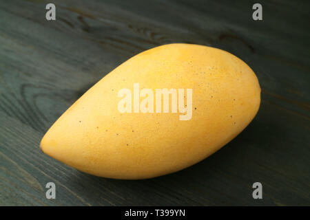 Closed up Thai Fresh Ripe Nam Dok Mai Mango Isolated on Wooden Table Stock Photo