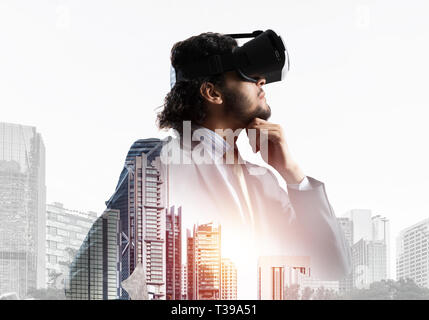 Double exposure of businessman in virtual helmet against cityscape background Stock Photo