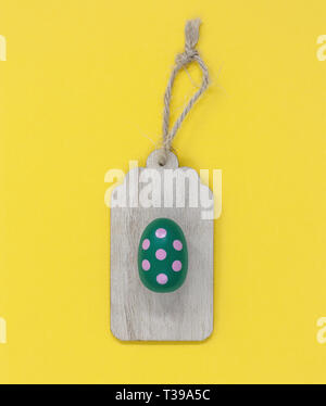 Easter egg wooden gift tag on a yellow background Stock Photo