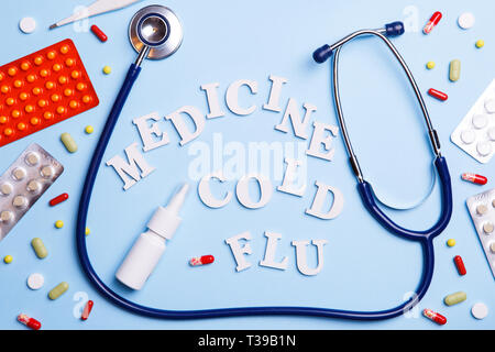 Cold medicine, thermometer, phonendoscope and words: medicine, cold, flu Stock Photo