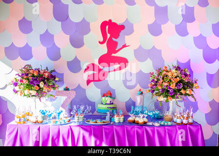 Sea time mermaid theme on the party's candy bar with purple background. Birthday party for girls, teens. Stock Photo