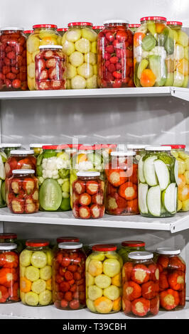 Traditional Romanian pickles of various fruits and vegetables on the shelves Stock Photo