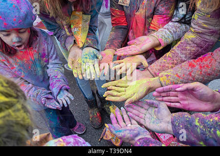 Children's hands at the Holi Parade on Liberty Ave in Richmond Hill, Queens, New York where it's customary to throw & smear colored powder.