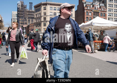 A young man shopping and wearing an Abraham Lincoln t shirt warning that not all of the internet is true. At the Union Square Green Market in New York Stock Photo