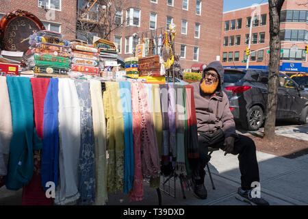 A Muslim man with his beard dyed orange, selling fabrics, books & religious items on 37th Avenue in Jackson Heights, Queens, New York City. Stock Photo