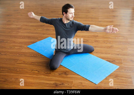 Supple man practicing yoga Stock Photo