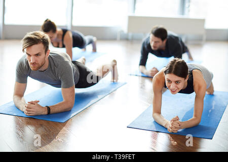 Motivated young people doing elbow plank Stock Photo