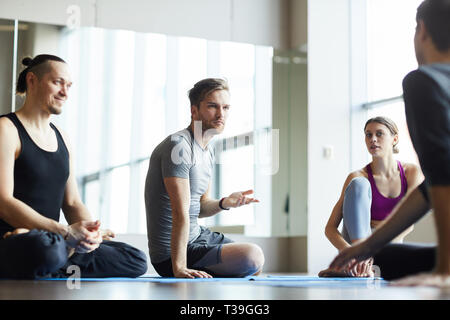 Students discussing training with yoga coach Stock Photo
