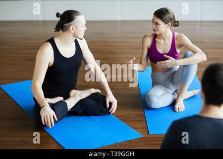 Flexible people talking in yoga class Stock Photo