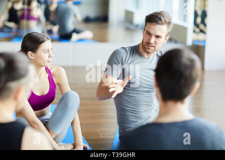 Sporty guy sharing ideas at yoga class Stock Photo