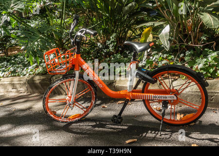 Sydney, Australia - February 12, 2019: Closeup of parked orange MOBIKE bicycle for rent as seen in Lang Park. Stock Photo