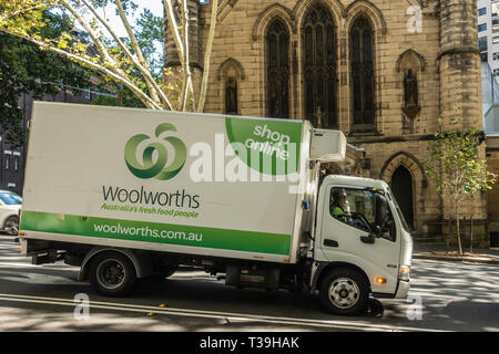 Sydney, Australia - February 12, 2019: Delivery van of Woolworths retail giant. Back is yellow facade of Saint Patricks Church. Stock Photo