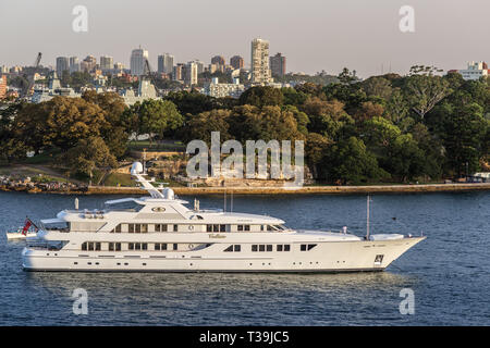 Sydney, Australia - February 12, 2019: The white luxurious Callisto yacht in the bay under an evening twilight sky. Stock Photo