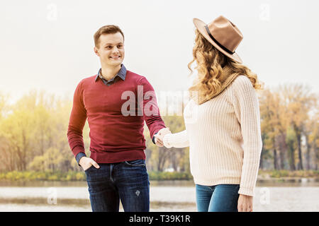 You are love of my whole life. Portrait of beautiful young couple holding hands together and looking at each other while standing outdoors. Couple in  Stock Photo