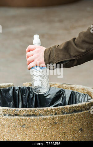 LAS VEGAS, NEVADA, USA - FEBRUARY 2019: Close up of a person disposing of an empty plastic water bottle in a rubbish bin on a street in Las Vegas. Stock Photo