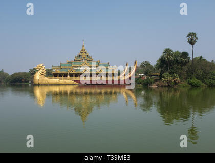 Royal barge and Karaweik or Karaweik Hall is a palace on the eastern shore of Kandawgyi Lake, Yangon, Myanmar Stock Photo