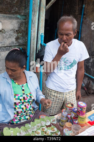 street vendor selling Paan (betel chewing) to a waiting customer ,  a preparation combining betel leaf with areca nut and sometimes also with tobacco  Stock Photo