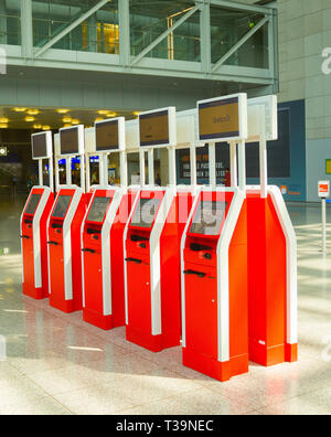 FRANKFURT AM MAIN, GERMANY - AUGUST 29, 2018: Red machines for self service at checkpoint in hall of Frankfurt airport, Germany Stock Photo
