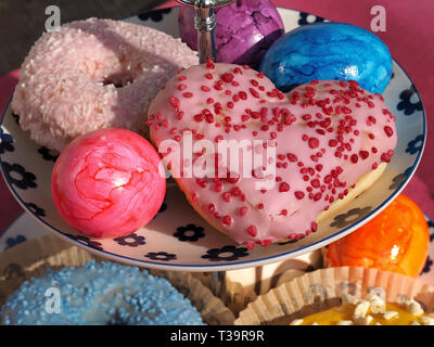 Arrangement of colorful doughnuts and easter eggs Stock Photo
