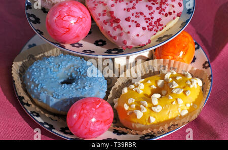 Arrangement of colorful doughnuts and easter eggs Stock Photo