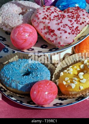 Arrangement of colorful doughnuts and easter eggs Stock Photo