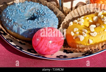 Arrangement of colorful doughnuts and easter eggs Stock Photo