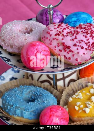 Arrangement of colorful doughnuts and easter eggs Stock Photo