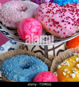 Arrangement of colorful doughnuts and easter eggs Stock Photo