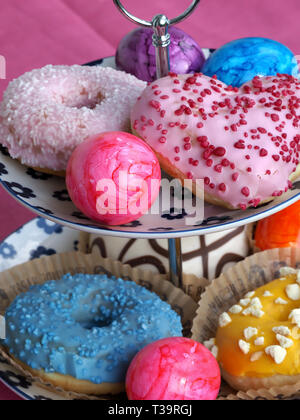 Arrangement of colorful doughnuts and easter eggs Stock Photo