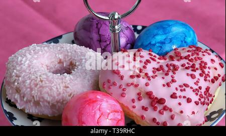 Arrangement of colorful doughnuts and easter eggs Stock Photo