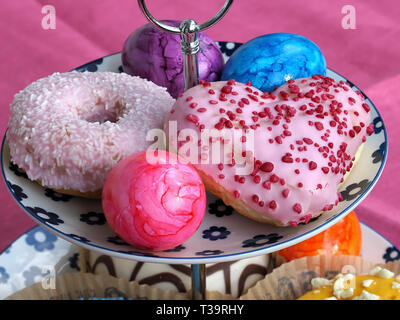 Arrangement of colorful doughnuts and easter eggs Stock Photo