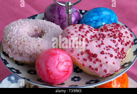 Arrangement of colorful doughnuts and easter eggs Stock Photo