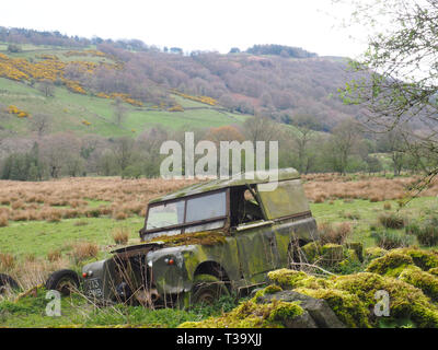 A decaying old Land Rover sinks into the land in the Peak DIstrict near Pott Shrigley, Cheshire, UK Stock Photo