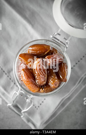 Blessed or kameen ramadan with dates fruit in a glass jar. Typical traditional Iftar food concept in islamic world. Top view with copy space. Selectiv Stock Photo