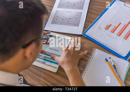 Businessman using tablet to check financial report Stock Photo
