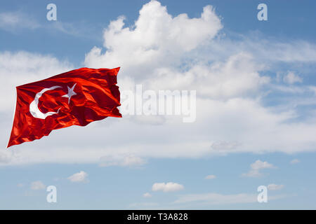 Turkish national flag with white star and moon in cloudy sky Stock Photo