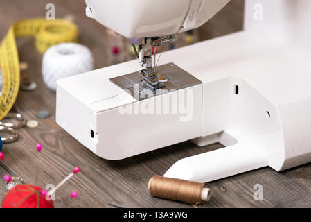 Seamstress or tailor background with sewing tools, colorful threads, sewing machine and accesories. Stock Photo