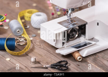Seamstress or tailor background with sewing tools, colorful threads, sewing machine and accesories. Stock Photo