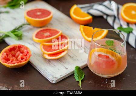 Ripe grapefruit and oranges with grapefruit juice on wooden table, Stock Photo