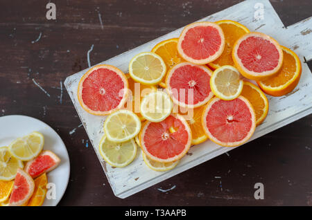 Grapefruits,lemons and oranges slices on the wooden background, top view Stock Photo