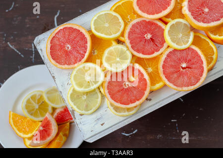 Grapefruits,lemons and oranges slices on the wooden background, top view Stock Photo