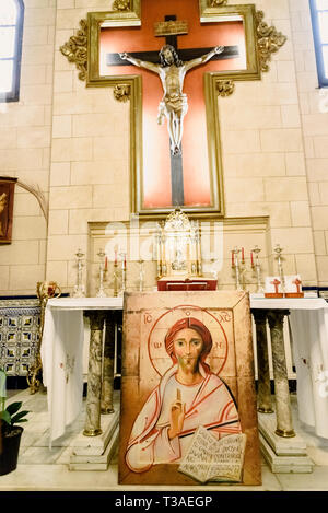 Valencia, Spain - March 30, 2019: Interior of a chapel of a Catholic church with a portrait of Jesus and crucifix on the altar. Stock Photo