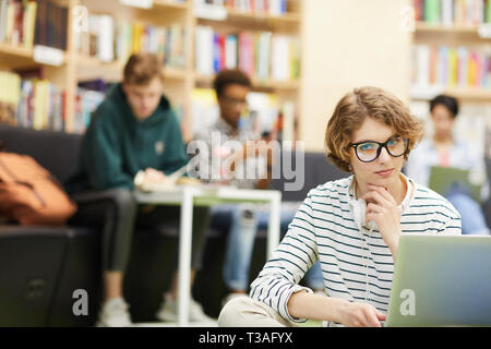 Smart student girl working on project in library Stock Photo