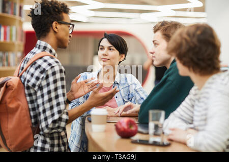 Multiethnic high school friends discussing project Stock Photo