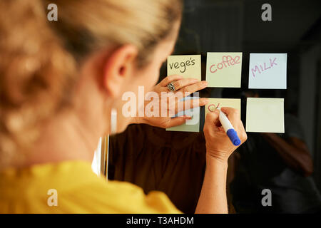 Woman writing shopping list Stock Photo